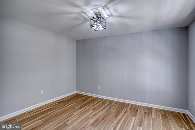 spare room featuring baseboards and light wood-type flooring