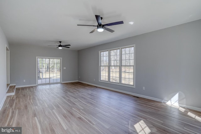 unfurnished living room with visible vents, wood finished floors, baseboards, and ceiling fan