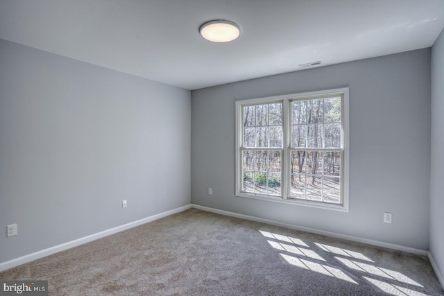 carpeted empty room featuring visible vents and baseboards