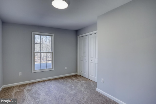 unfurnished bedroom featuring a closet, carpet flooring, and baseboards