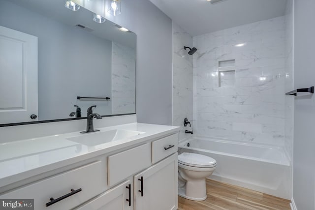 bathroom with visible vents, toilet, shower / washtub combination, wood finished floors, and vanity