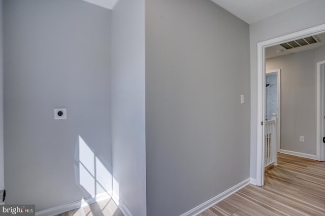 corridor featuring baseboards, visible vents, and light wood-type flooring