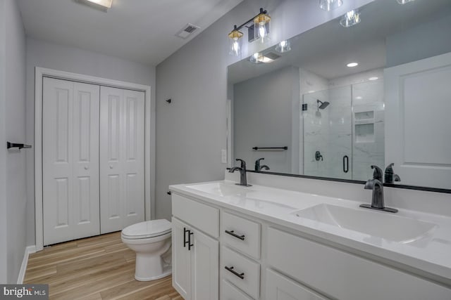 full bath with a sink, visible vents, a stall shower, and wood finished floors