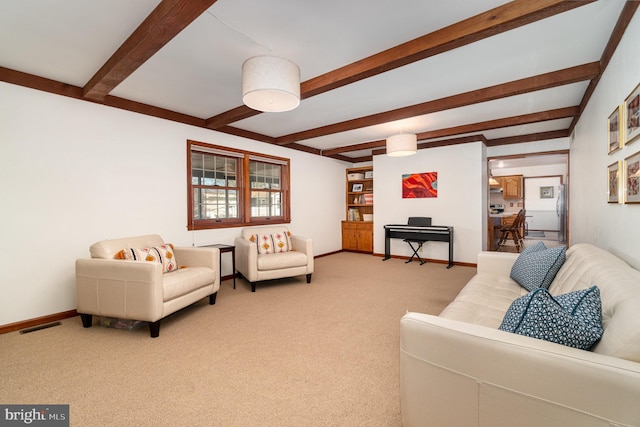 living area with beamed ceiling, baseboards, visible vents, and light carpet