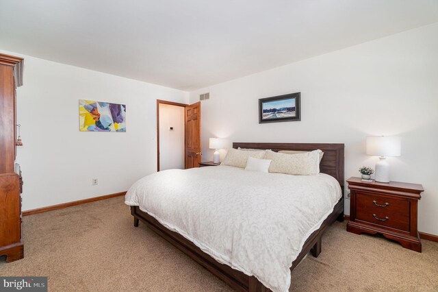 bedroom with visible vents, baseboards, and light colored carpet