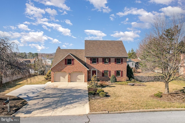 colonial-style house featuring concrete driveway, a front yard, a garage, brick siding, and a chimney