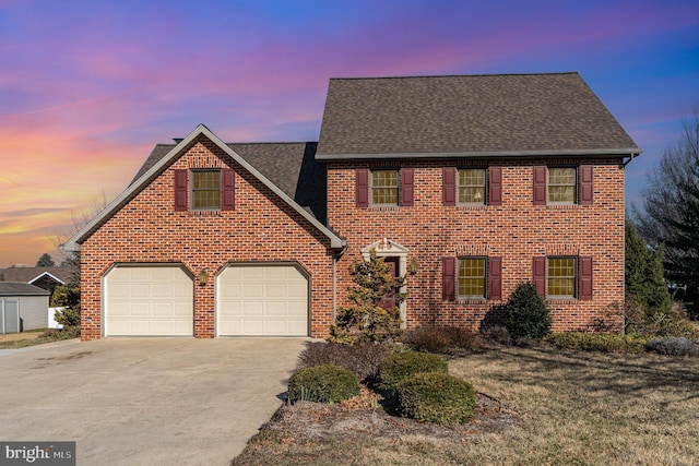 view of front facade featuring brick siding, driveway, a shingled roof, and a garage