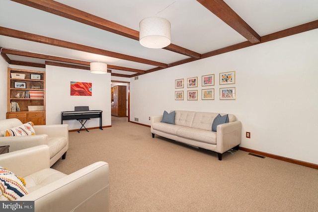 living area featuring visible vents, beamed ceiling, baseboards, and carpet