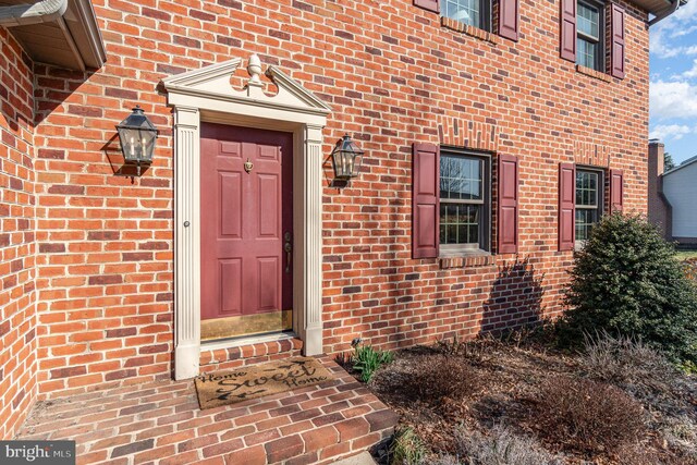 property entrance featuring brick siding