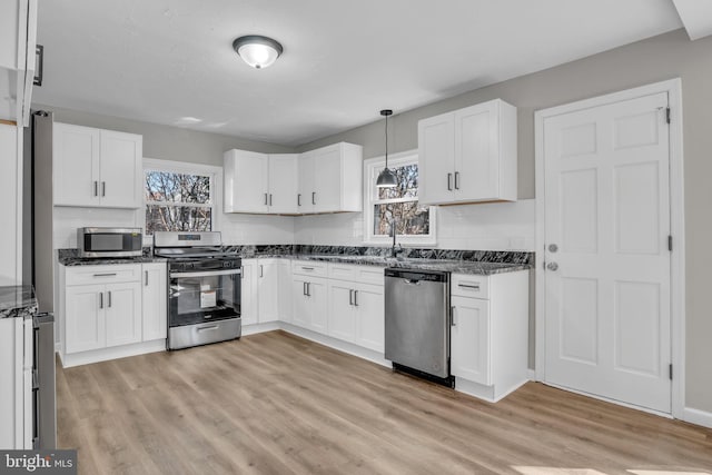 kitchen featuring white cabinetry, light wood finished floors, plenty of natural light, and appliances with stainless steel finishes