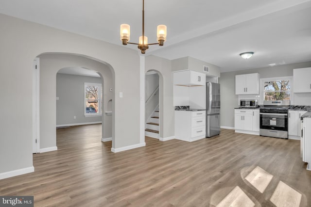 kitchen featuring visible vents, appliances with stainless steel finishes, light wood-style flooring, and white cabinets