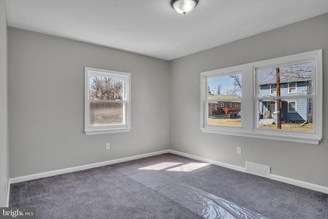 carpeted empty room with visible vents and baseboards