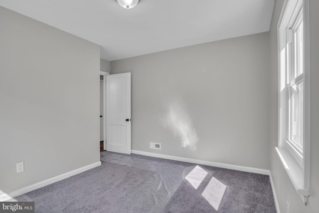 spare room featuring baseboards and carpet