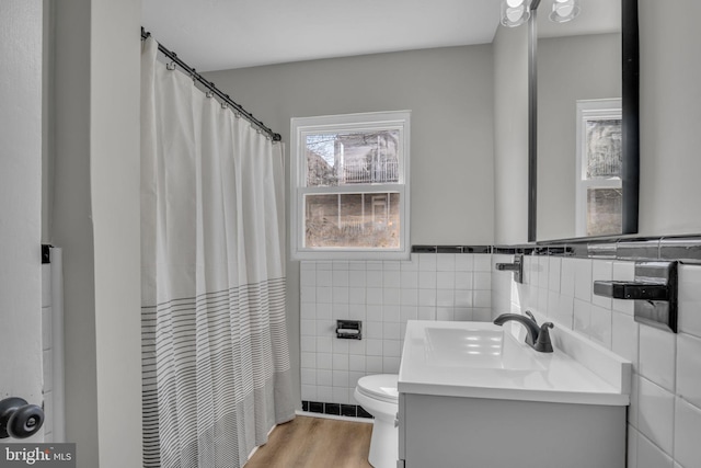 bathroom with vanity, a shower with curtain, wood finished floors, tile walls, and toilet