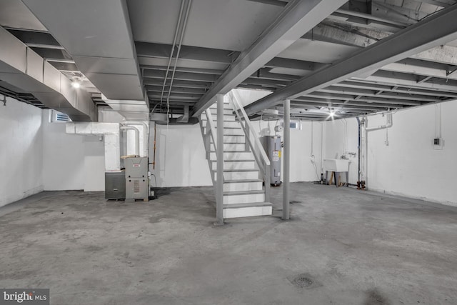 below grade area featuring stairway, water heater, heating unit, concrete block wall, and a sink