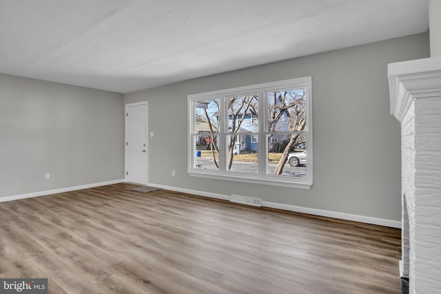 interior space featuring wood finished floors, baseboards, and visible vents