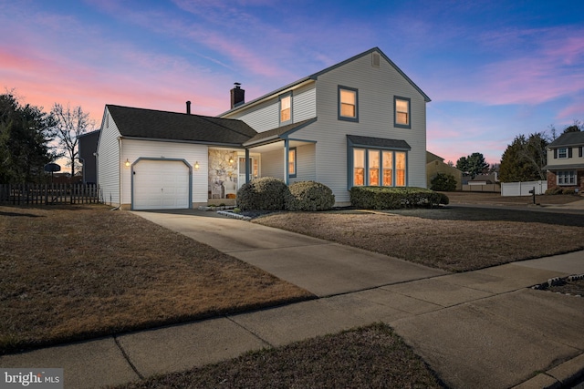 traditional home with a garage, concrete driveway, a chimney, and fence