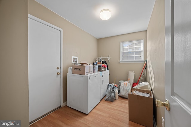 washroom featuring separate washer and dryer, laundry area, and light wood finished floors