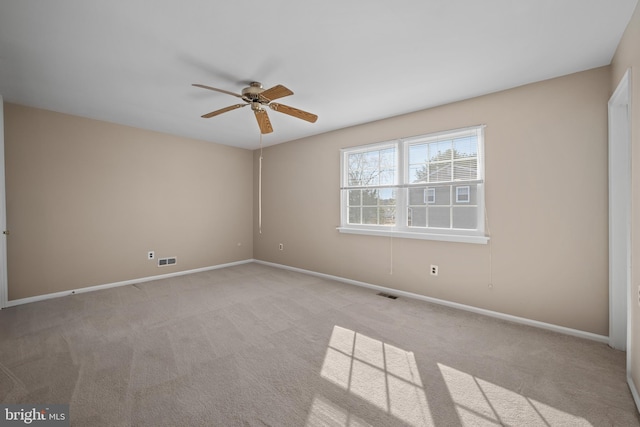 empty room with visible vents, light carpet, baseboards, and ceiling fan