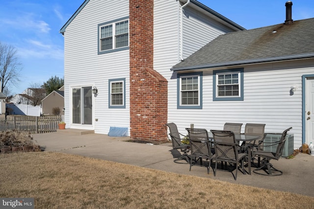 back of house featuring a shingled roof, fence, central AC unit, a chimney, and a patio area