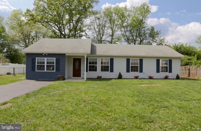 ranch-style home featuring a front lawn and fence