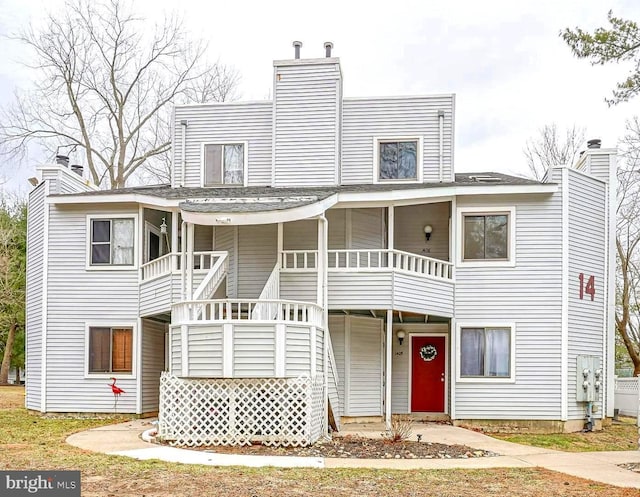 view of front of property featuring stairway, a porch, and a chimney