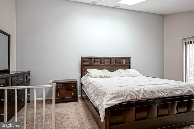 bedroom featuring a skylight, baseboards, and carpet floors