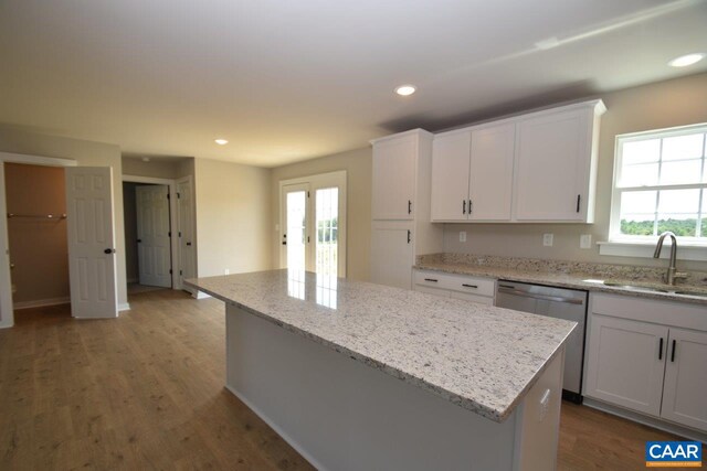 kitchen with a kitchen island, dishwasher, recessed lighting, white cabinetry, and a sink