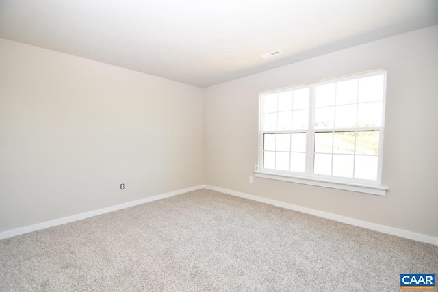 carpeted empty room featuring baseboards