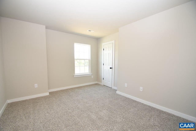 unfurnished room featuring visible vents, light colored carpet, and baseboards