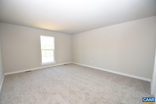 spare room featuring baseboards and carpet floors