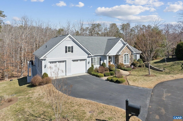 view of front of home with stairs, a front yard, a garage, stone siding, and driveway