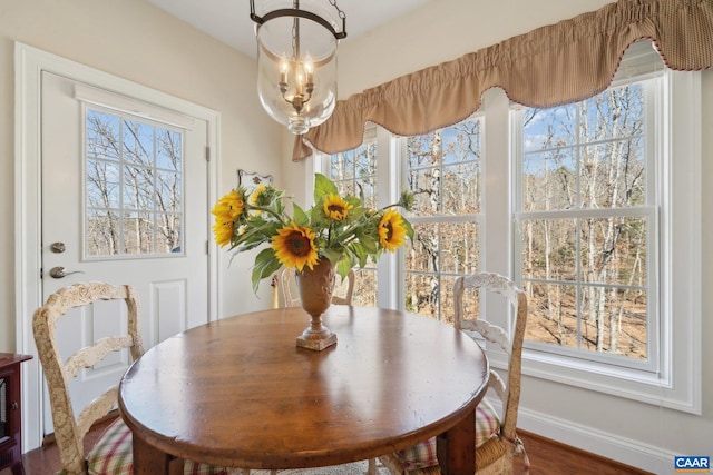 dining area featuring wood finished floors, baseboards, and a chandelier