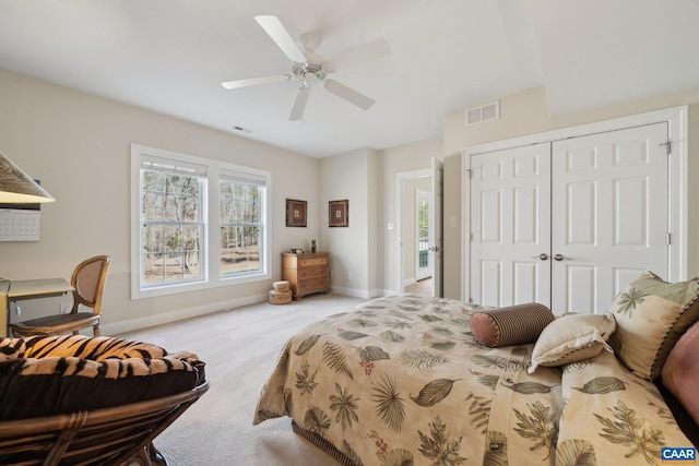 carpeted bedroom with a ceiling fan, baseboards, visible vents, and a closet