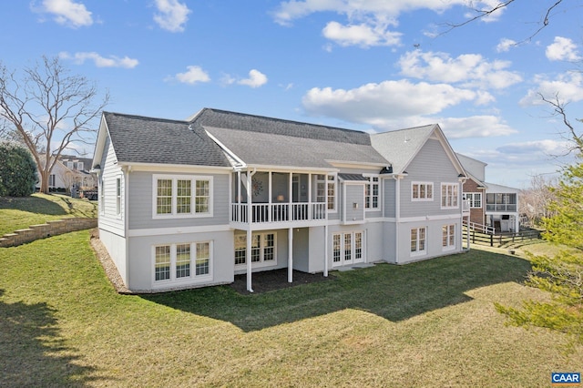 back of house featuring french doors, a lawn, a shingled roof, and a sunroom