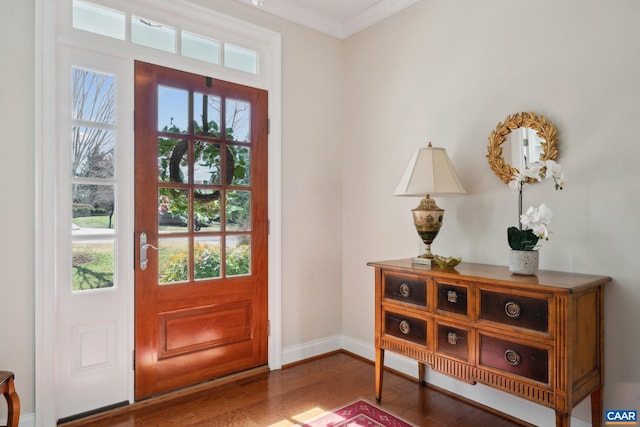 entryway with baseboards, plenty of natural light, wood finished floors, and crown molding