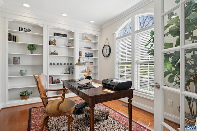 office area with built in shelves, wood finished floors, baseboards, recessed lighting, and ornamental molding