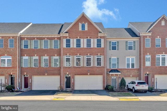 view of property featuring an attached garage, brick siding, and driveway