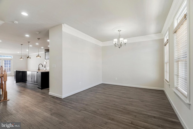 unfurnished dining area featuring crown molding, baseboards, recessed lighting, dark wood-style floors, and a sink