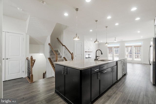 kitchen with dark wood-style floors, dark cabinets, appliances with stainless steel finishes, and a sink