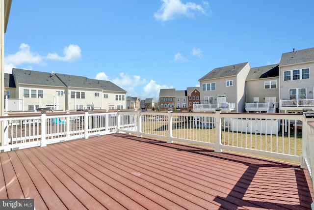 wooden deck featuring a residential view and a lawn