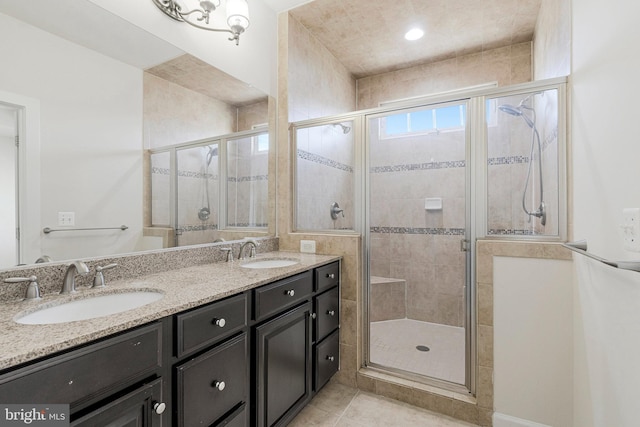 full bath featuring double vanity, a stall shower, tile patterned floors, and a sink