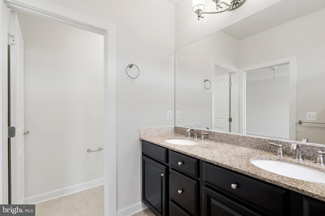 bathroom with a sink, baseboards, and double vanity