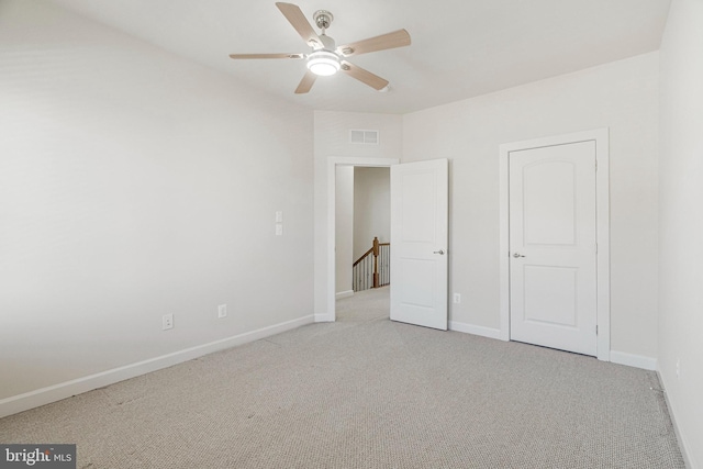 unfurnished bedroom with baseboards, carpet floors, visible vents, and a ceiling fan