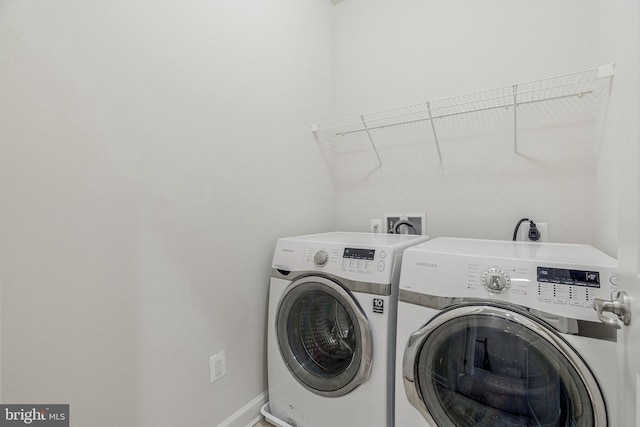 laundry room featuring laundry area, washing machine and dryer, and baseboards