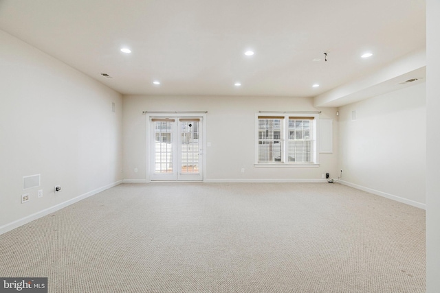 unfurnished living room with recessed lighting, baseboards, and light carpet