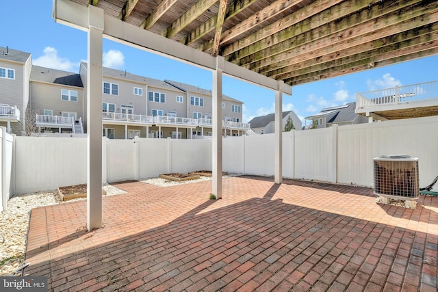 view of patio featuring central air condition unit, a fenced backyard, and a residential view