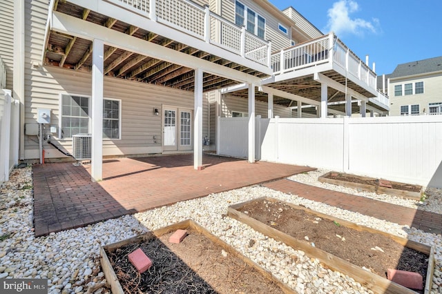 view of patio featuring central air condition unit, french doors, a wooden deck, and fence