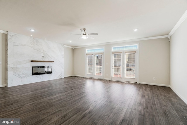 unfurnished living room featuring ornamental molding, a ceiling fan, heating unit, dark wood-style floors, and a high end fireplace