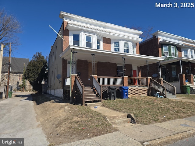 view of front of house featuring brick siding and covered porch